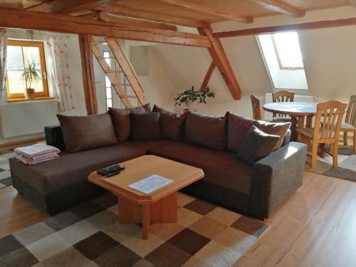 a living room with a brown couch and a table at Ferienwohnung mit Charme und Blick auf Dinkelsbühl in Dinkelsbühl