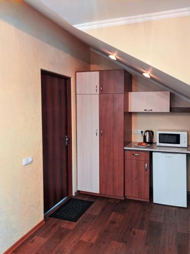 a small kitchen with a sink and a refrigerator at Котедж-парк Славна in Okhtyrka