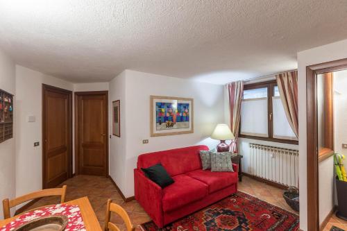 ein Wohnzimmer mit einem roten Sofa und einem Tisch in der Unterkunft L'Atelier du Temps - Maison Germain in Courmayeur