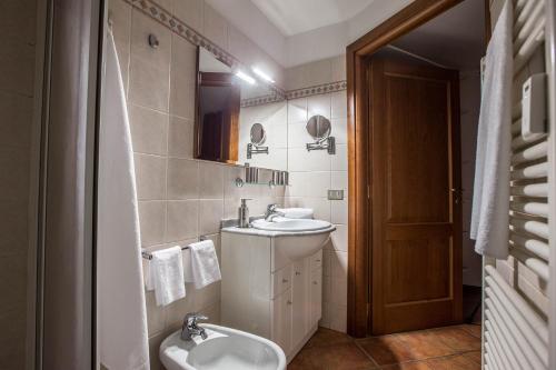 ein Badezimmer mit einem Waschbecken, einem WC und einem Spiegel in der Unterkunft L'Atelier du Temps - Maison Germain in Courmayeur
