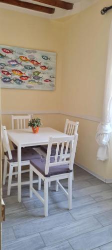 a white dining room table with two chairs and a painting at Soggiorno dell Agnolo in Florence