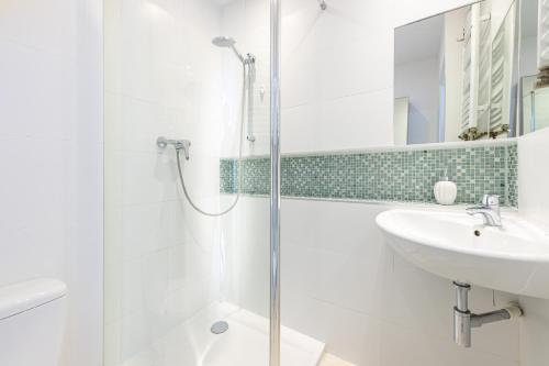 y baño con ducha y lavamanos. en Victus Apartamenty, Apartament Sunshine, en Sopot