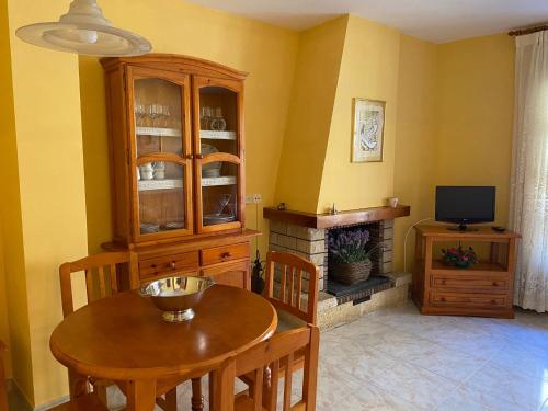 uma sala de jantar com uma mesa de madeira e uma televisão em Apartaments Montaña em Alins
