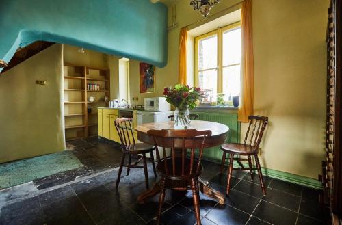 eine Küche mit einem Tisch und Stühlen sowie einem Fenster in der Unterkunft Carréhoeve in het iconisch heuvellandschap in Noorbeek