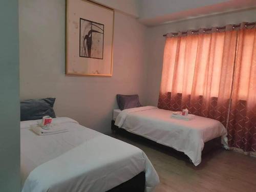 Pokój z 2 łóżkami i oknem w obiekcie White Knight Hotel Saint Anne w mieście Manila