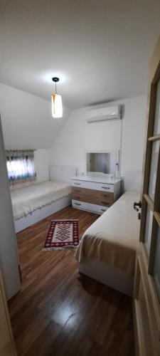 a bedroom with a bed and a dresser and a mirror at Villa "GREEN PARADISE" in Divjakë