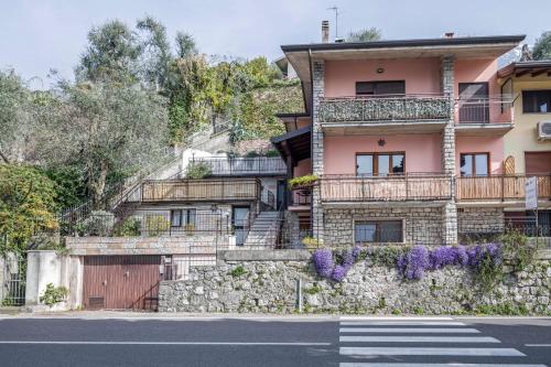 a house on a hill with a stone wall at Appartamento Fiocco in Malcesine