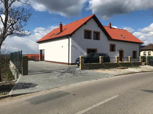 a white house with an orange roof on a street at U Floderů in Bavory