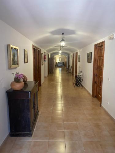 a hallway with a long hallway with a tile floor at MONASTERIO de SANTA MARÍA DE VALVANERA in Anguiano