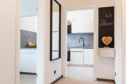 a kitchen with white cabinets and a mirror at Uiferhäuser in Illmitz