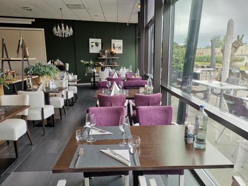 a restaurant with purple chairs and tables and windows at Resort Land & Zee in Scharendijke