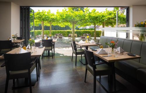 a restaurant with tables and chairs and a large window at Hotel zur Post Riesenbeck in Riesenbeck
