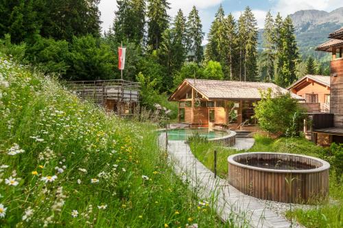 a garden with a pool and a house at Hotel Bad Schörgau in Sarntal