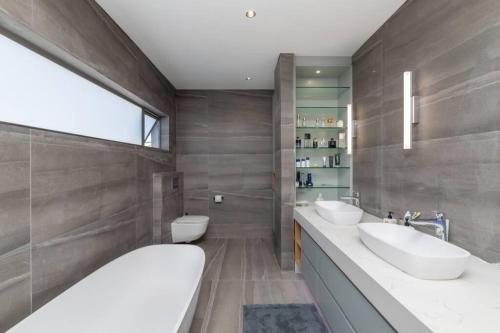 a bathroom with two sinks and two toilets at Stunning Villa de Soleil in Cape Town