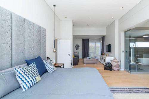 a bedroom with a blue bed and a living room at Stunning Villa de Soleil in Cape Town