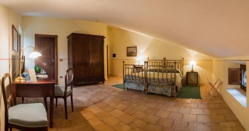 a bedroom with a bed and a table and a desk at Torre Camigliati Dimora Storica in Camigliatello Silano