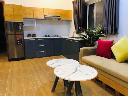 a kitchen and a living room with a couch and a table at Casa Vi Mia in Ấp Thiện Sơn