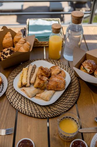 a table with a plate of pastries and orange juice at Costa D' Ifesto in Agios Ioannis Kaspaka