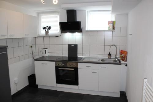 a small kitchen with white cabinets and a sink at Ferienwohnung Morgentau in Germersheim