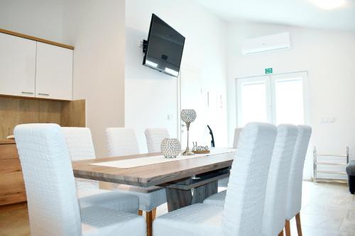 Televízia a/alebo spoločenská miestnosť v ubytovaní Apartmani Lovrenčić