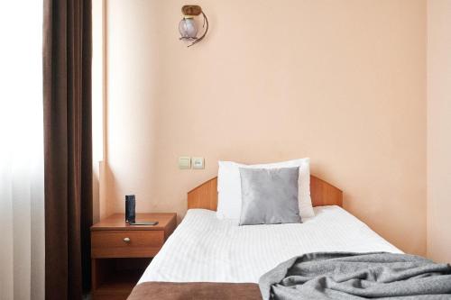 a small bedroom with a bed and a nightstand at Hotel Druzhba in Kyiv