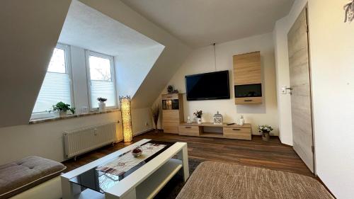 ein Wohnzimmer mit einem Sofa und einem TV in der Unterkunft ViLLA LiNDENECK SUPERIOR in Bernburg