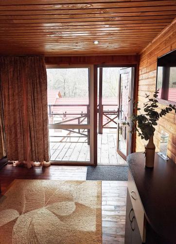 a living room with a large sliding glass door at Котедж-парк Славна in Okhtyrka