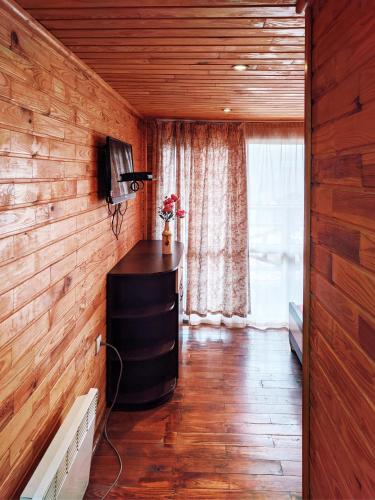 a room with a television and a wooden wall at Котедж-парк Славна in Okhtyrka