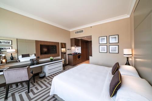 a hotel room with a bed and a desk at Al Maha Arjaan by Rotana in Abu Dhabi