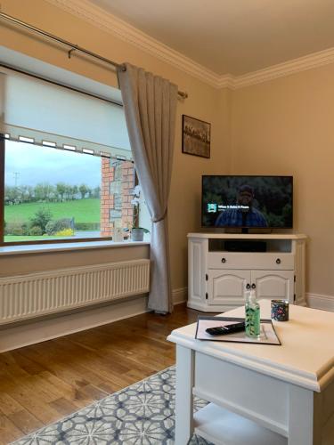 uma sala de estar com uma televisão e uma mesa em Carraig House em Cavan