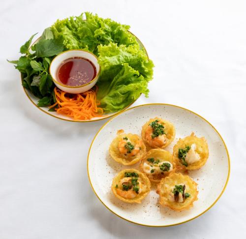 a plate of food with shrimp and a salad at Fusion Suites Vung Tau in Vung Tau