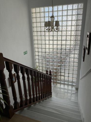 eine Treppe mit einem großen Fenster und einem Kronleuchter in der Unterkunft Hotel Venta del Pobre in Níjar