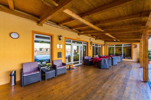 a room with chairs and tables and a clock on the wall at Hotel & Motorest V Údolí Zlatého potoka in Blšany