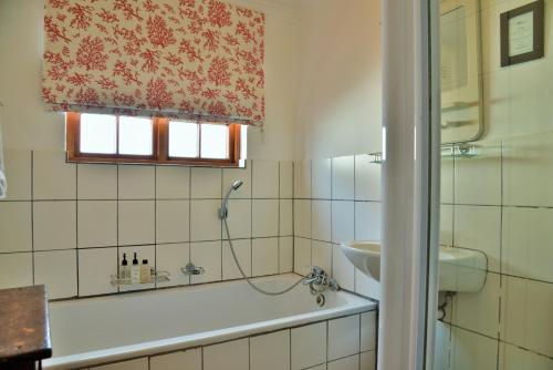 a bathroom with a bath tub and a sink at De Hoop Collection - Opstal Houses in De Hoop Nature Reserve