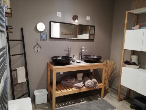 a bathroom with two sinks and a mirror at Au Logis de la Mongie in Soullans