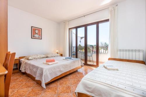 a bedroom with two beds and a balcony at Apartments Banko in Rovinj