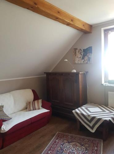 a living room with a couch and a window at Kurnik Polski agroturystyka in Tykocin