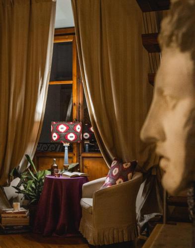 a living room with a chair and a table and a curtain at Capri Moon Guest House in Florence