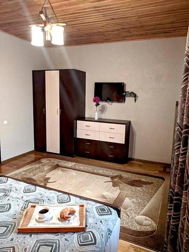 a living room with a tv and a table on the floor at Котедж-парк Славна in Okhtyrka