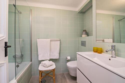 Un baño con lavabo, inodoro y ducha. en Casa O12, en Vilamoura