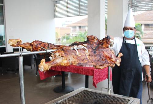 a man in apron holding a roast turkey on a table at Holiday Inn Melaka by IHG in Melaka