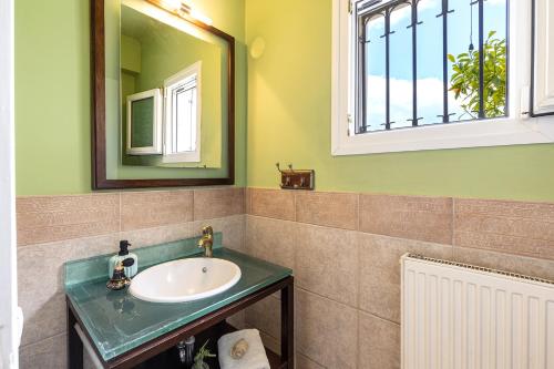 a bathroom with a sink and a mirror at Spyrelia Villa with Private Pool & Outdoor Hot Tub in Dassia