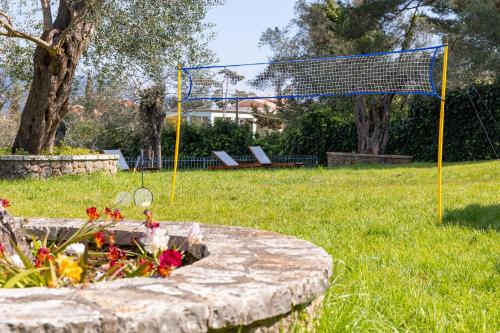 a volleyball net and flowers in a park at Spyrelia Villa with Private Pool & Outdoor Hot Tub in Dassia