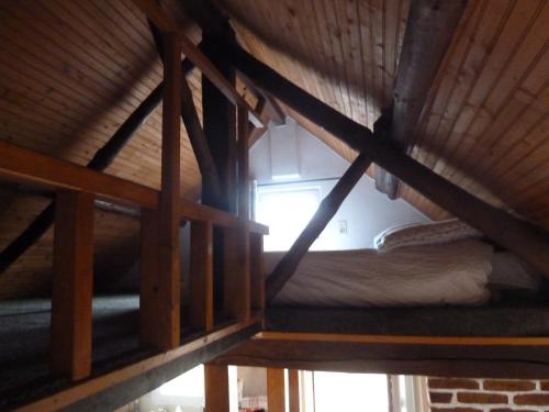 an attic room with a bunk bed and a window at La Petite maison en Sologne in Salbris