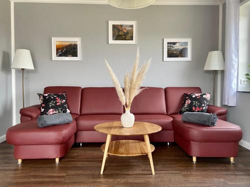 a living room with a red couch and a table at Landhaus Waltersdorf in Bad Schandau