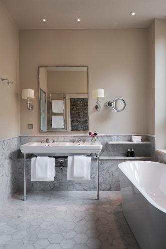 a bathroom with a sink and a tub and a mirror at Villa Dagmar in Stockholm
