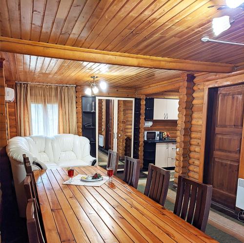 a living room with a table and a white couch at Котедж-парк Славна in Okhtyrka
