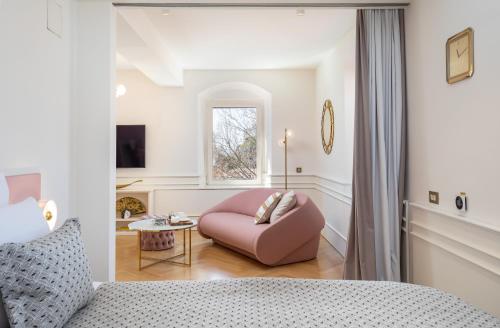 sypialnia z różowym krzesłem i oknem w obiekcie Deluxe Studio Rennesance Corner w Dubrowniku