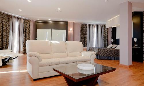 a living room with a white couch and a table at Hotel Campos de Baeza in Baeza