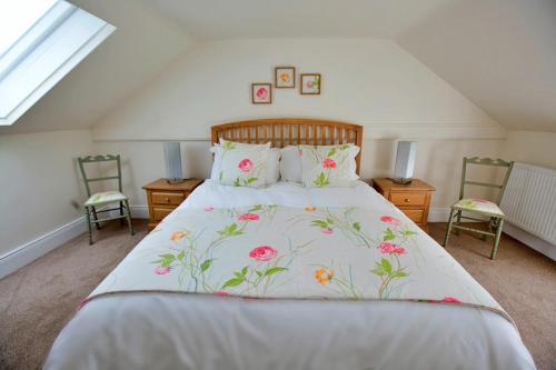 a bedroom with a large bed with flowers on it at Finest Retreats - Shortflatt Farm Cottage in Belsay